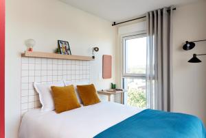 a bedroom with a bed and a window at Hife Toulouse Sud Labège in Labège