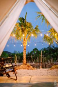 a view of a palm tree from a tent at LALASEA BISTRO (Camping, Food & Drink) in Ha Tien