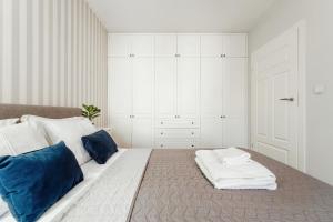 ein Schlafzimmer mit einem großen Bett mit blauen und weißen Kissen in der Unterkunft Apartament Premium Plac Litewski 7 in Lublin