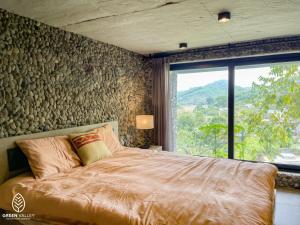 1 dormitorio con 1 cama grande y ventana grande en Green Valley Cao Sơn en Hòa Bình