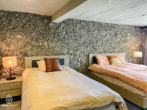 2 camas en una habitación con una pared cubierta de papel pintado en Green Valley Cao Sơn en Hòa Bình