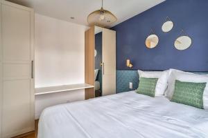 um quarto com uma grande cama branca e uma parede azul em Splendid apartment for 2 people em Aubervilliers