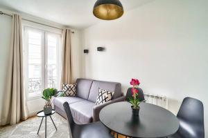 un soggiorno con divano e tavolo di Splendid apartment for 2 people ad Aubervilliers