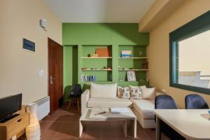 a living room with green walls and a couch at City Center Modern Penthouse in Heraklio Town