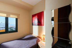 イラクリオン・タウンにあるCity Center Modern Penthouseのベッドルーム1室(ベッド1台、大きな窓付)
