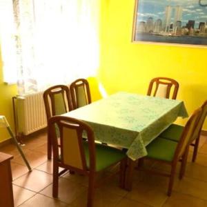 uma mesa de jantar com 4 cadeiras e uma mesa verde em Sziszi nyaralóház em Balatonszárszó
