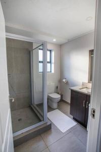 Un baño con ducha de cristal y un inodoro. en 29 eastpoint@pointwaterfront, en Durban 5 fotos más