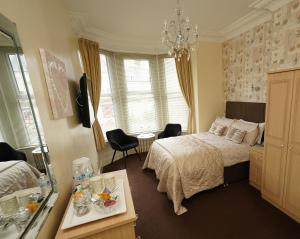 a bedroom with a bed and a chandelier at The Rosedene in Llandudno