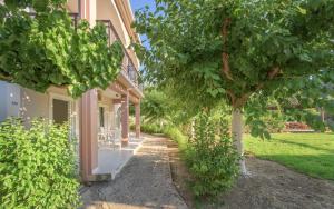 a house with a pathway next to a tree at Natasa Studios in Laganas