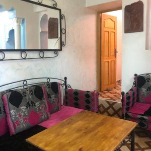 een kamer met een tafel en stoelen en een spiegel bij Blue heart in Chefchaouene