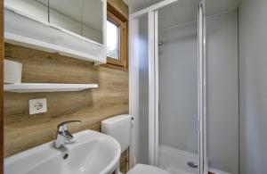 La salle de bains est pourvue de toilettes, d'un lavabo et d'une douche. dans l'établissement Camping-und Ferienpark Havelberge, à Groß Quassow