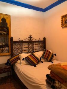 a bedroom with a bed with two pillows on it at Blue heart in Chefchaouen