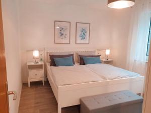 a bedroom with a large white bed with two lamps at Fewo Rosalie in Norddeich