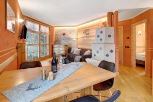 jadalnia i salon ze stołem i krzesłami w obiekcie Tramonto Villa Nordica w Livigno