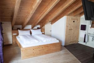 ein Schlafzimmer mit einem Bett in einem Zimmer mit Holzdecken in der Unterkunft Gästehaus Münchner Kindl in Reit im Winkl