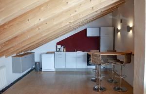 cocina con armarios blancos y techo de madera en Gästehaus Münchner Kindl, en Reit im Winkl