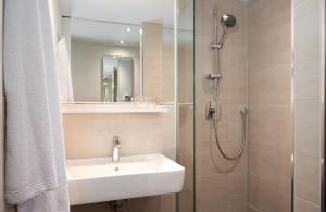 ein Badezimmer mit Waschbecken und Dusche in der Unterkunft Leonardo Hotel Vienna City West in Wien