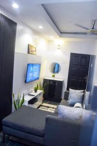 a living room with a bed and a tv at The Grenadines Apartment in Lagos