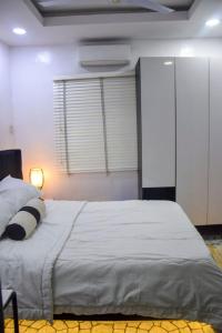 a bedroom with a large white bed with a window at The Grenadines Apartment in Lagos