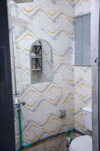 a bathroom with a shower with a toilet at The Grenadines Apartment in Lagos