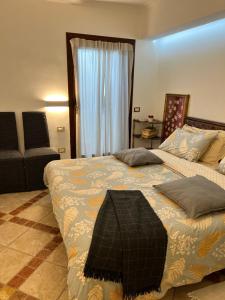ein Schlafzimmer mit einem Bett mit einer Decke und einem Stuhl in der Unterkunft la casetta tra la laguna e il mare Poetto in Cagliari