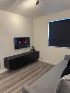 a living room with a flat screen tv on a wall at Apartment Close to the Studios in Borehamwood