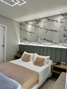 1 dormitorio con 1 cama grande y pared de mármol en Hotel Ibicui, en Rosário do Sul