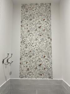 - un rideau de douche avec un motif floral dans la salle de bains dans l'établissement Côté Nuit, à Capestang