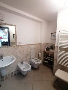 Un baño con lavabo, inodoro y espejo. en Orbetello centro - Tramonto di Ponente casa indipendente, en Orbetello