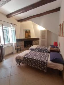 1 dormitorio con 2 camas y chimenea en Orbetello centro - Tramonto di Ponente casa indipendente, en Orbetello
