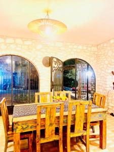 una sala da pranzo con tavolo e sedie in legno di Villa Maison des Arts - Oasis de Calme et Tranquillité Près de l'Aéroport d'Essaouira a Essaouira
