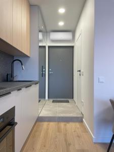 a kitchen with white cabinets and a glass door at Apartment in Vilnius in Vilnius