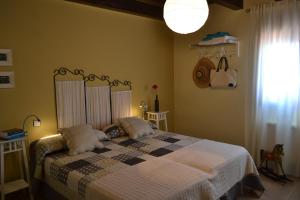 a bedroom with a bed with a checkered blanket at La Cantamora Hotel Rural Pesquera de Duero in Pesquera de Duero