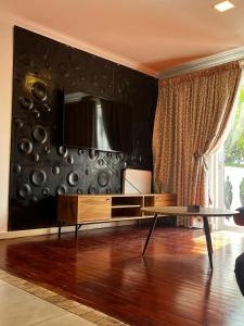 uma sala de estar com uma mesa e uma televisão na parede em Lagoon Lodge em Cidade do Cabo