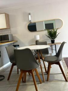 a dining room with a table and four chairs at Lagoon Lodge in Cape Town