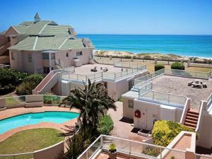 an aerial view of a house with a swimming pool and the ocean at Summerseas in Summerstrand