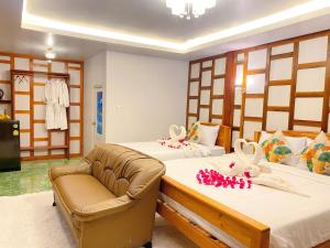 Relaxing House Koh Yao Yai في كو ياو ياي: غرفة فندقية بسريرين واريكة