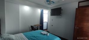 a bedroom with a bed and a tv on the wall at Hotel Grand Paradise Marcona in San Juan
