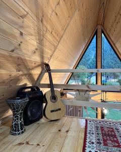 uma guitarra está pendurada no tecto de uma sala em Borjomi Story em Borjomi