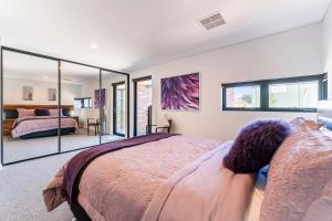 1 dormitorio con 1 cama grande y espejo grande en Luxury Getaway Home, en Byford
