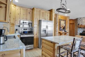 cocina con armarios de madera y nevera de acero inoxidable en COMSTOCK 203 condo, en Park City