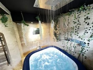 a bathroom with a tub with plants on the wall at The Coxhill Retreat - Indoor Rainforest Spa Stay in Dover