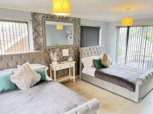 1 dormitorio con 2 camas y sofá en The Coxhill Retreat - Indoor Rainforest Spa Stay en Dover