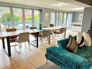 een woonkamer met een bank en een tafel en stoelen bij The Coxhill Retreat - Indoor Rainforest Spa Stay in Dover