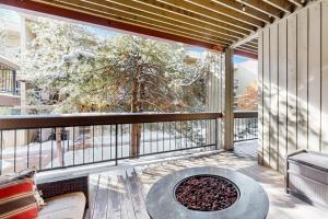 a balcony with a fire pit and a large window at SunRiver E102 in Avon