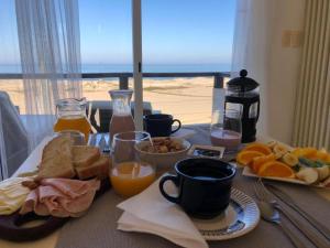 a table with breakfast food and a view of the beach at Remanso del Diablo in Punta Del Diablo