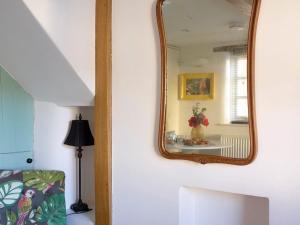 a mirror on a white wall in a room at The Coach House - Market Deeping in Market Deeping