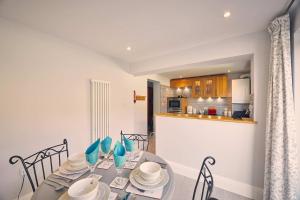 a dining room with a table and chairs and a kitchen at Host & Stay - Roselyn By The Sea in Newbiggin-by-the-Sea