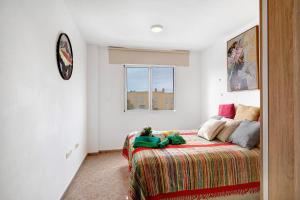 1 dormitorio con 1 cama y reloj en la pared en Apartamento Rebeca en Tazacorte