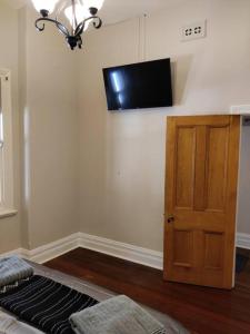 a room with a flat screen tv on the wall at North Perth Stylish Character Home Close CBD in Perth